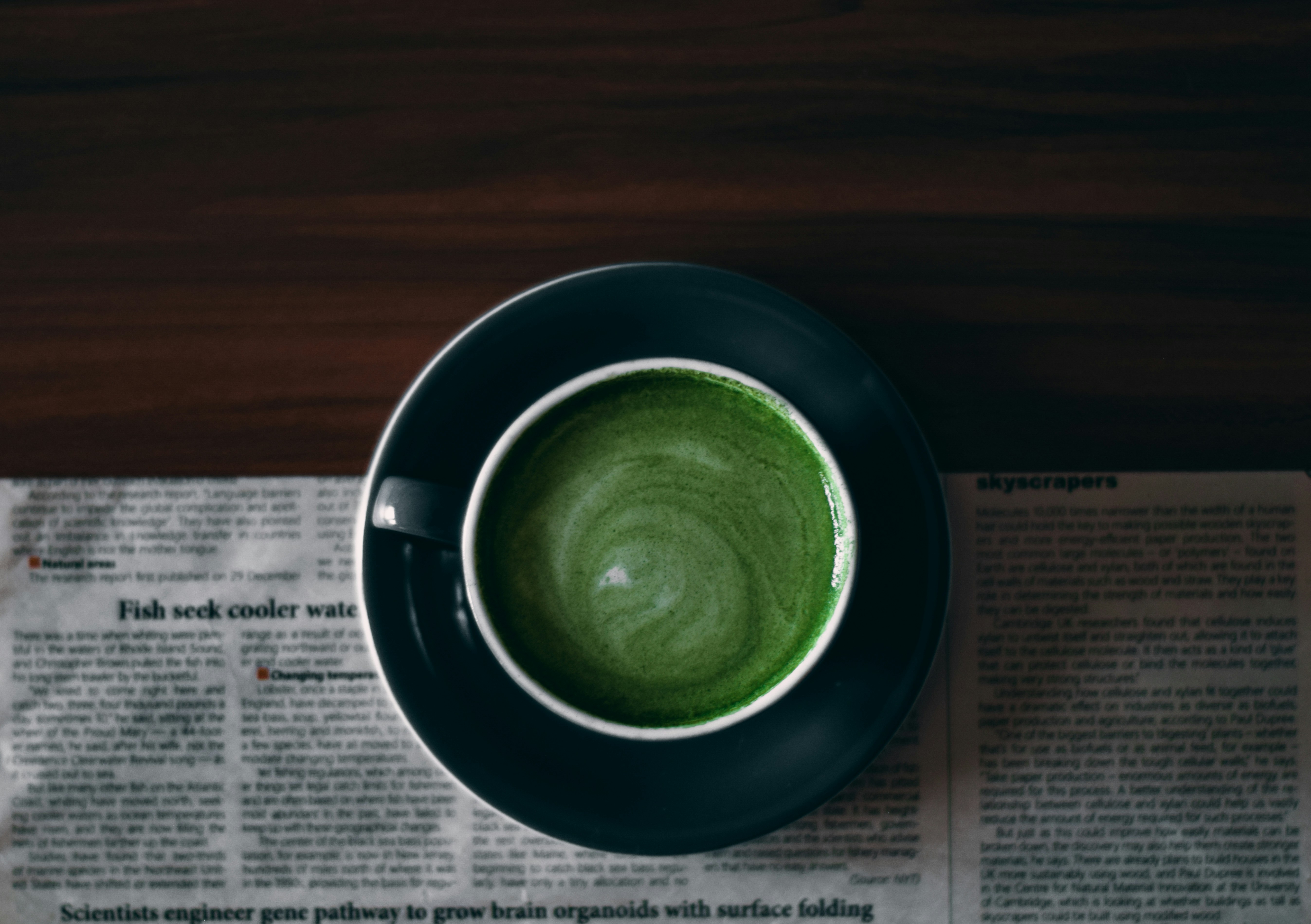 A cup of matcha resting on the morning newspaper