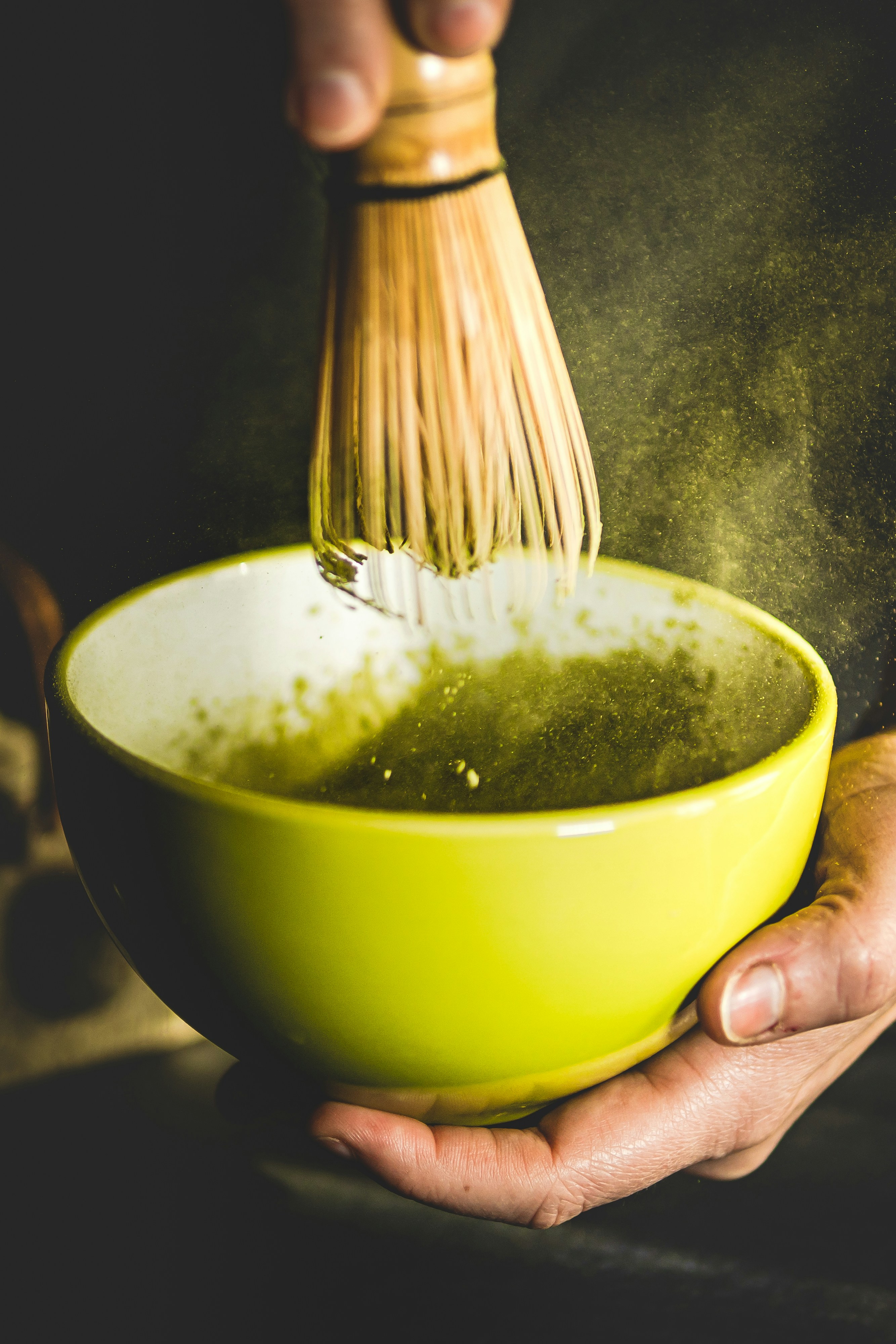 Whisking matcha into a smooth foam with a bamboo chasen